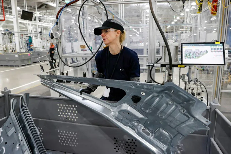 An employee works on an assembly line at startup Rivian Automotive's electric vehicle factory in Normal, Ill. (Reuters/Kamil Krzaczynski/File Photo)