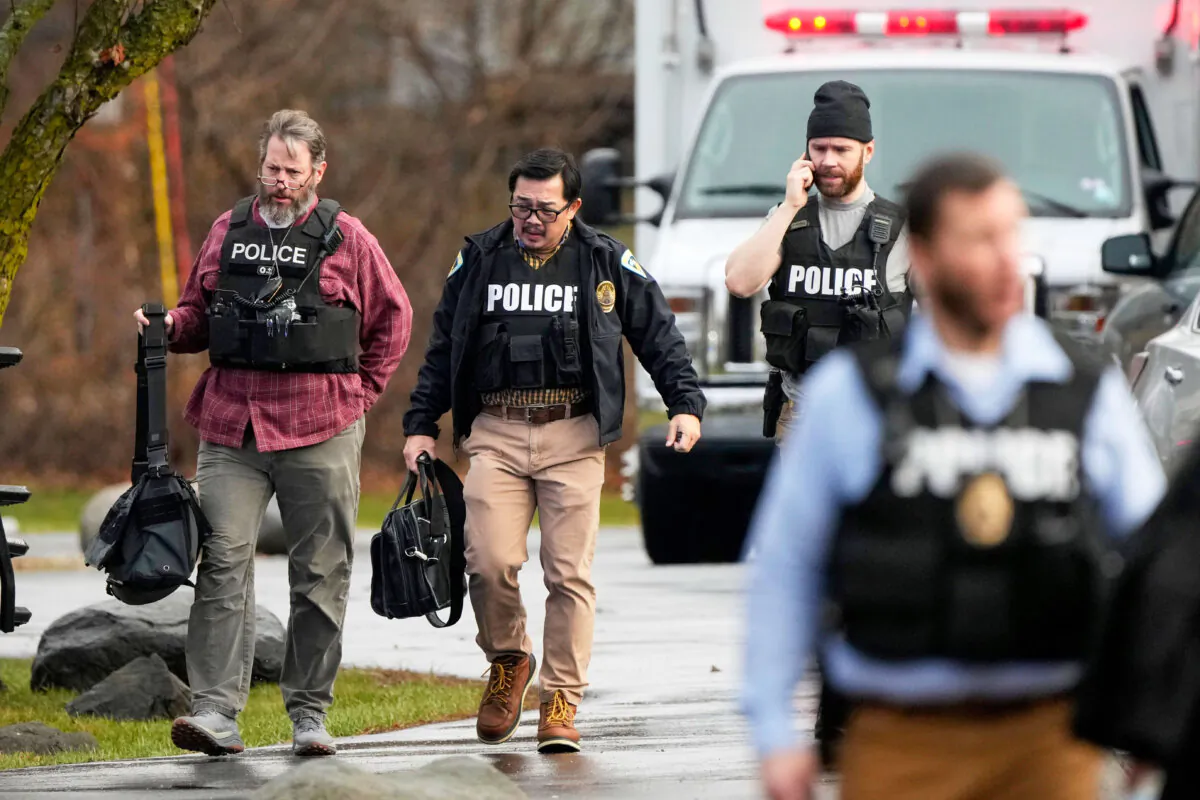 Police walk outside the Abundant Life Christian School following a shooting in Madison, Wis., on Dec. 16, 2024. (AP Photo/Morry Gash)