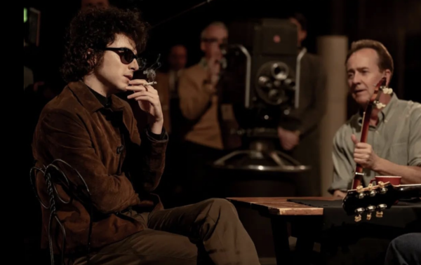 man with sunglasses and cigarette and man with banjo in A Complete Unknown