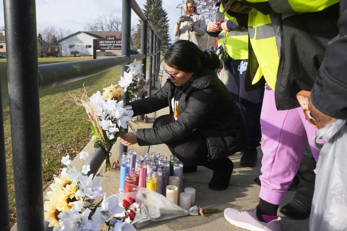 A resident places some flowers outside the Abundant Life Christian School in Madison, Wis., on Dec. 17, 2024, following a shooting on Dec. 16. (Morry Gash/AP Photo)
