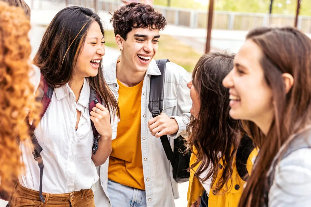 University students talk and laugh together at a college campus in a stock photo. (DavideAngelini/Shutterstock)