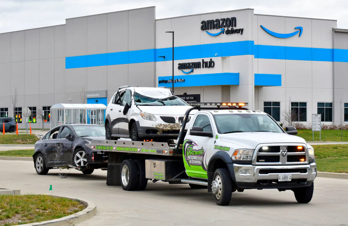 A tow truck removes destroyed cars from an Amazon fulfillment center following a tornado, in Edwardsville, Ill., on Dec. 11, 2021. (Tim Vizer/AFP via Getty Images)