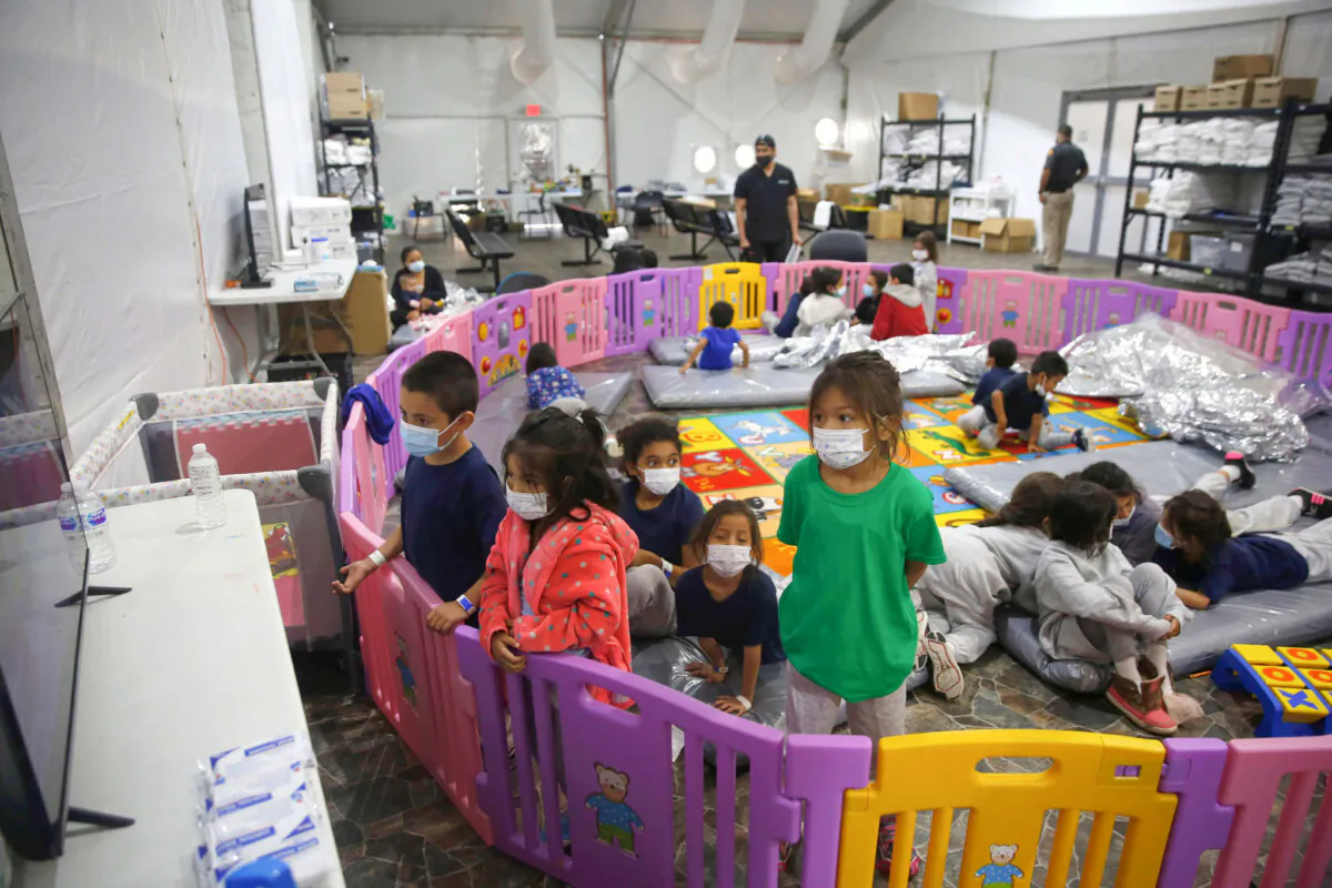 Young unaccompanied illegal immigrants, from ages 3 to 9, watch television inside a playpen at the U.S. Customs and Border Protection facility, the main detention center for unaccompanied children in the Rio Grande Valley, in Donna, Texas, on March 30, 2021. (Dario Lopez-Mills/Pool/AP Photo)