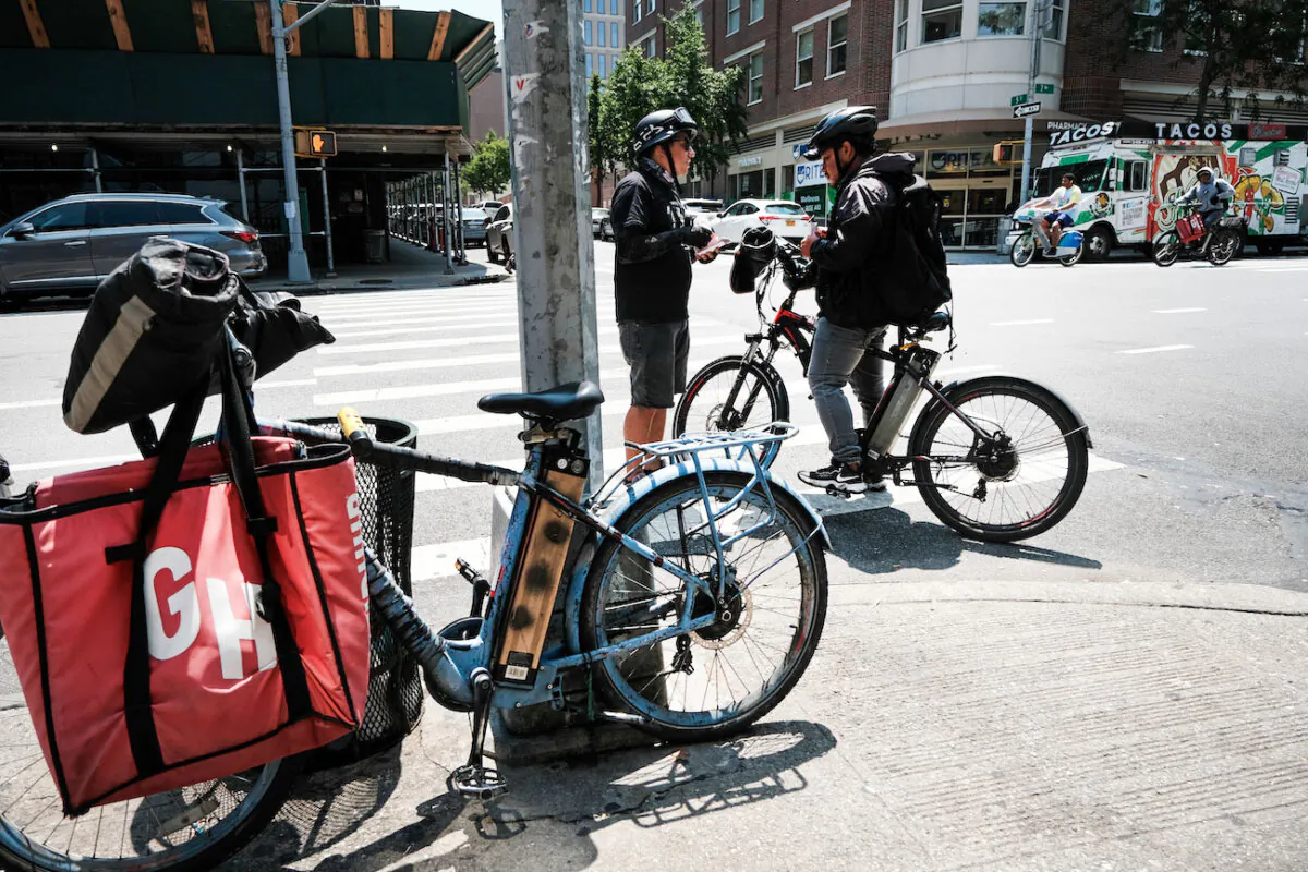 A person speaks to a delivery worker outside of a restaurant that uses app deliveries, in New York City on July 7, 2023. (Spencer Platt/Getty Images)