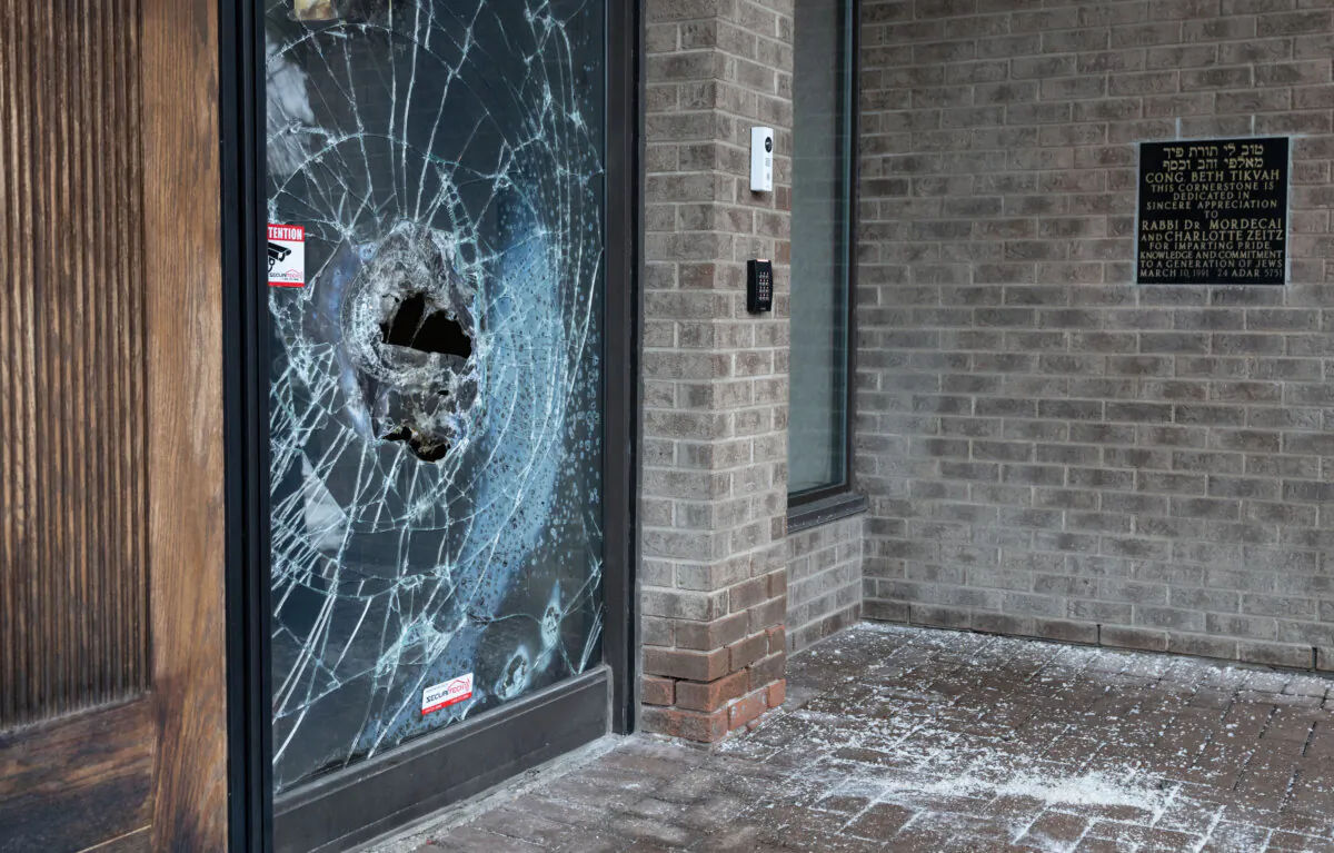A broken window is seen on the doors of Congregation Beth Tikvah, as police investigate a firebombing attack on the synagogue in the Montreal suburb of Dollard-des-Ormeaux on Dec. 18, 2024. (The Canadian Press/Christinne Muschi)