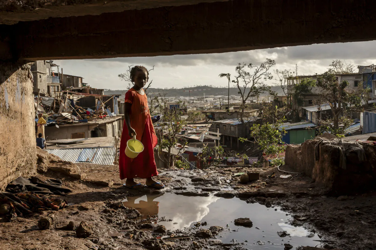 A young girl walks in the Kaweni slum on the outskirts of Mamoudzou, in the French Indian Ocean island of Mayotte, on Dec. 19, 2024, after Cyclone Chido. (Adrienne Surprenant/AP Photo)