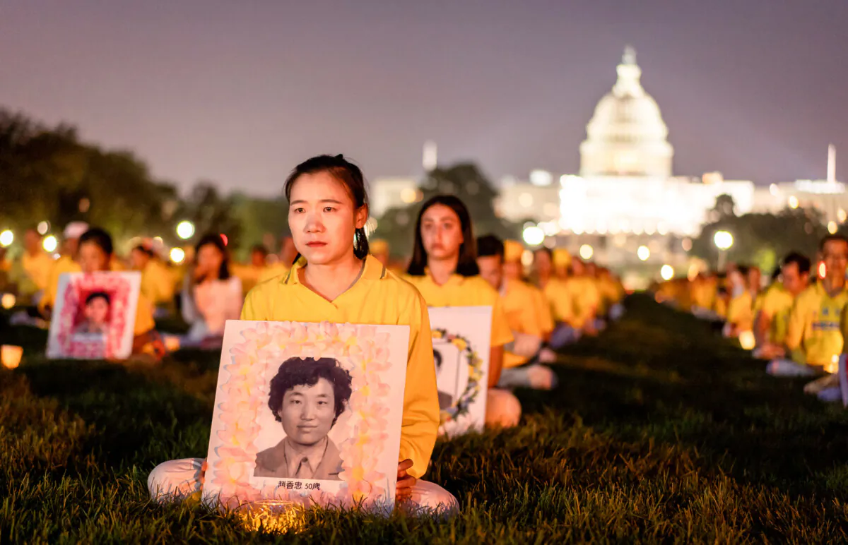 Falun Gong practitioners take part in a candlelight vigil in memory of Falun Gong practitioners who passed away due to the Chinese Communist Party’s 24 years of persecution, at the National Mall in Washington on July 20, 2023. (Samira Bouaou/The Epoch Times)