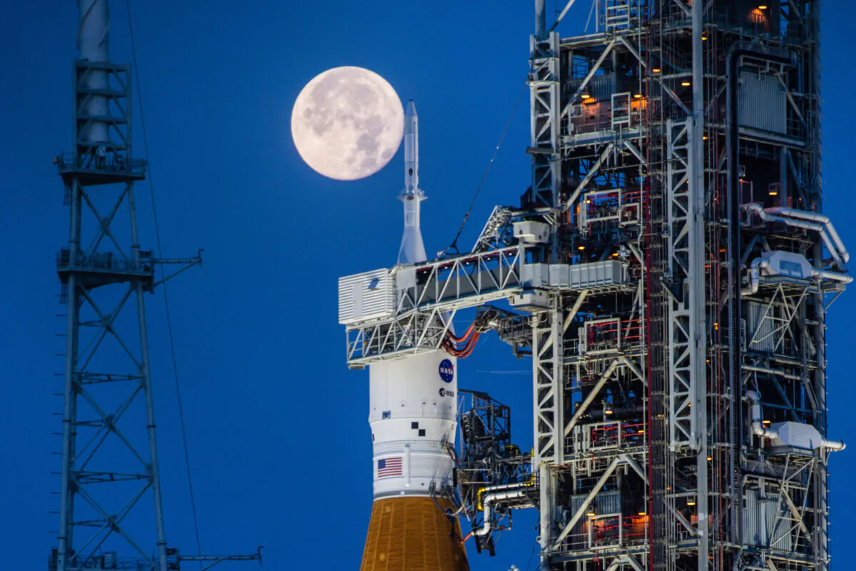A full Moon is seen behind the Artemis I Space Launch System and Orion spacecraft, atop the mobile launcher at Launch Complex 39B at NASA's Kennedy Space Center in Florida on June 14, 2022. (Cory Huston/NASA via AP)
