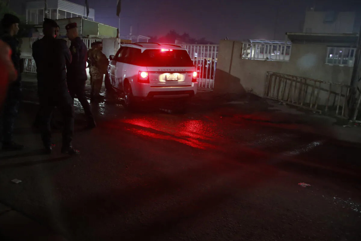 Iraqi security forces gather outside a morgue of Sheikh Zayed Hospital in Baghdad, Monday, Nov. 7, 2022, where a U.S. citizen who worked for an international aid organization was taken after he was fatally shot. (Hadi Mizban/AP Photo)