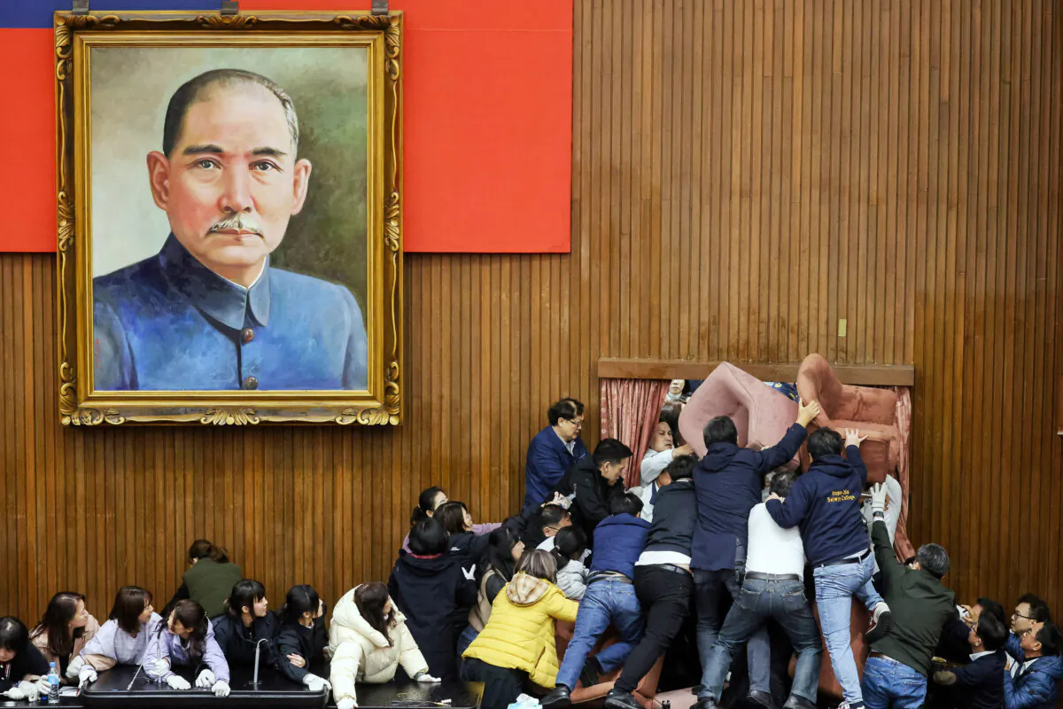 Lawmakers from the main opposition Kuomintang (in white) try to break into Parliament, which was occupied by the Democratic Progressive Party to avoid the passing of the third reading of amendments to the Civil Servants Election and Recall Act and other controversial bills at the Legislative Yuan in Taipei, Taiwan, on Dec. 20, 2024. (I-Hwa Cheng/AFP via Getty Images)