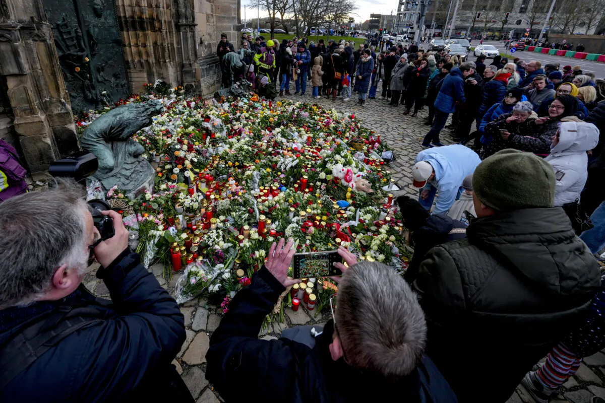 People lay flowers at the entrance of a church near a Christmas Market, where a car drove into a crowd on Friday evening, in Magdeburg, Germany, Saturday, Dec. 21, 2024. (Michael Probst/AP Photo)
