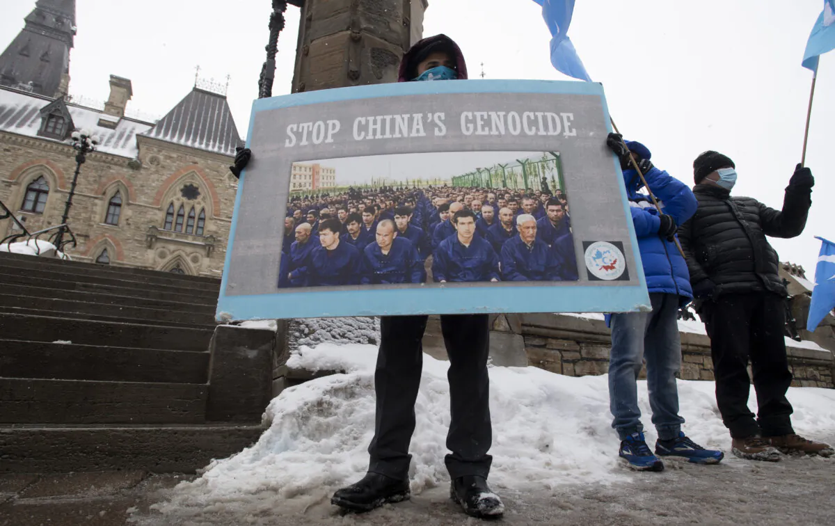 Protesters against China's abuse of Uyghur Muslims gather outside the Parliament buildings in Ottawa on Feb. 22, 2021, as MPs vote on a motion calling on Canada to recognize China's actions against the ethnic minority as genocide. (The Canadian Press/Adrian Wyld)