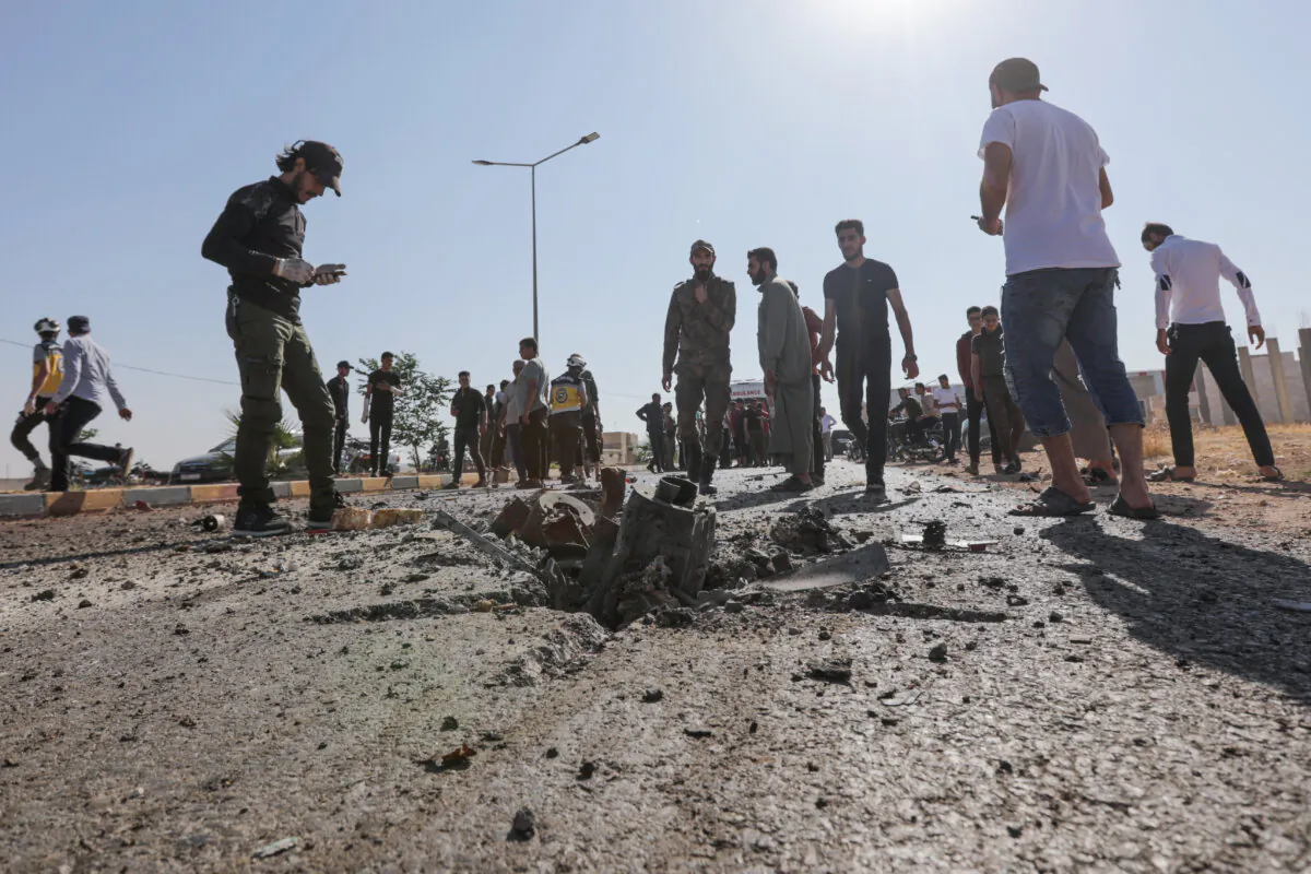 People gather at the site of a reported drone strike in Syria's Aleppo governorate on July 7, 2023. (Bakr Alkasem/AFP via Getty Images)