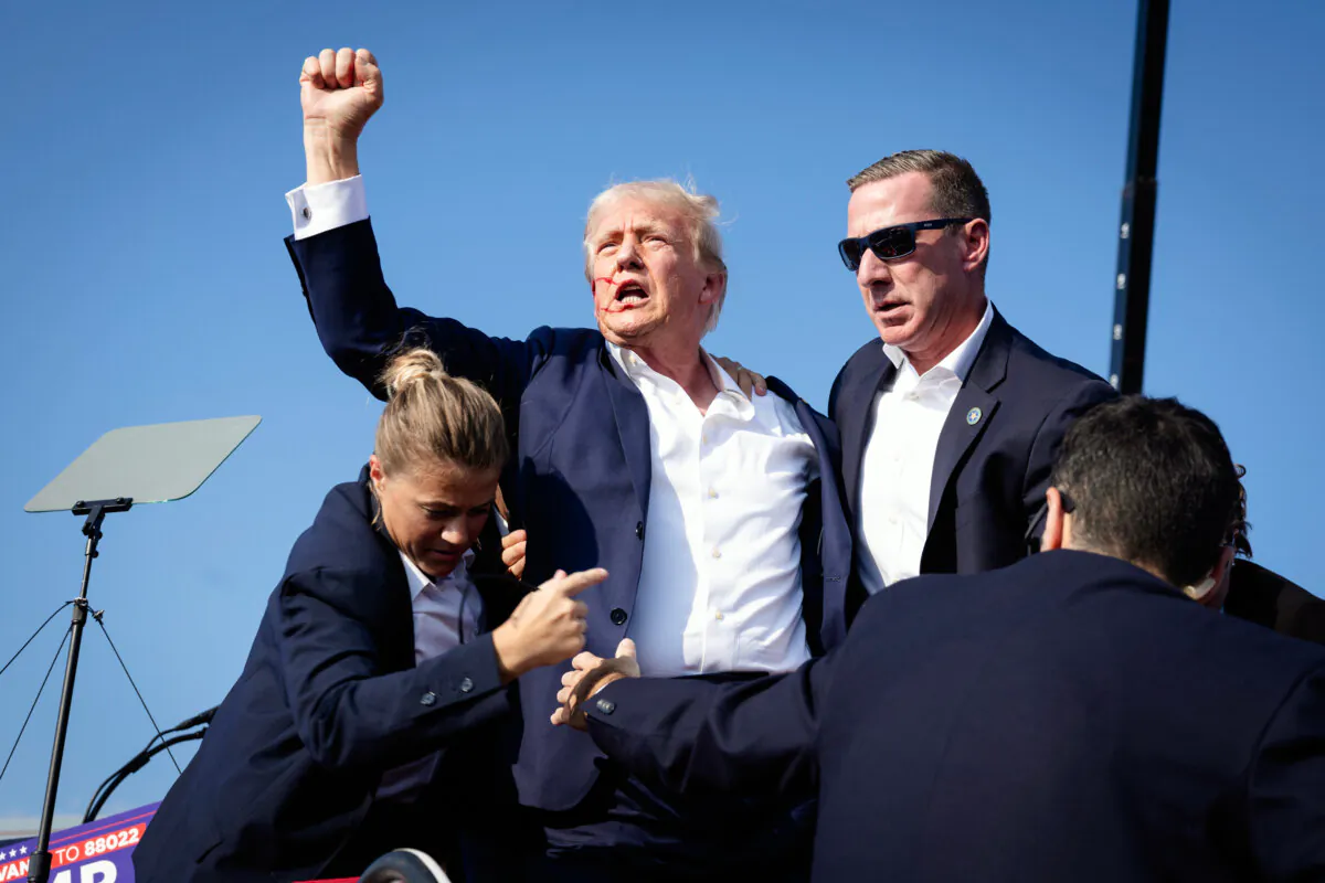 U.S. Secret Service agents rush to protect former President Donald Trump after shots were fired during a campaign rally in Butler, Pa., on July 13, 2024. (Anna Moneymaker/Getty Images)