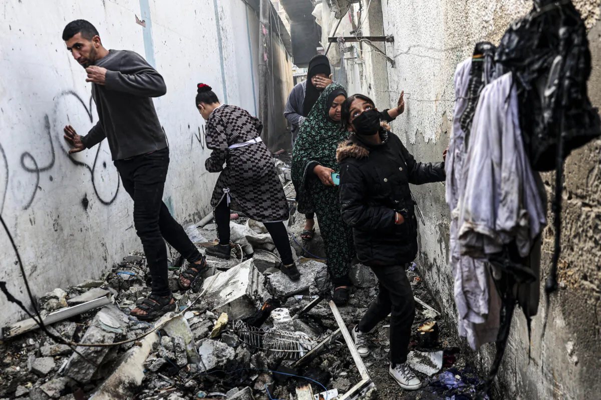 People find their way through a rubble-covered alley following overnight Israeli bombardment amid continuing battles between Israel and Hamas in Rafah, in the Gaza Strip, on Feb. 25, 2024. (Said Khatib/AFP via Getty Images)
