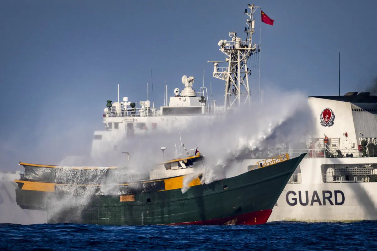A Chinese Coast Guard ship fires a water cannon at Unaizah, a Philippine Navy chartered vessel, conducting a routine resupply mission to troops stationed at Second Thomas Shoal in the South China Sea on March 5, 2024. (Ezra Acayan/Getty Images)