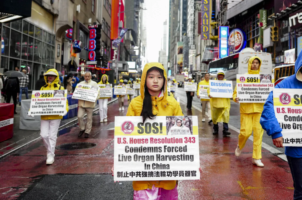 Falun Gong practitioners take part in a parade in New York City on May 10, 2024, to celebrate World Falun Dafa Day while calling for an end to the persecution of the spiritual practice in China. The placards they hold raise awareness of the Chinese regime's state-sanctioned forced organ harvesting, which primarily targets Falun Gong practitioners. (Samira Bouaou/The Epoch Times)