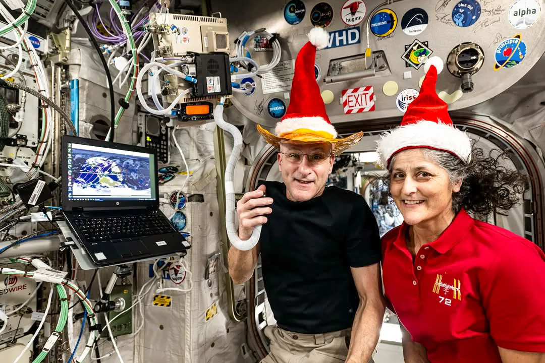 Astronauts Don Pettit and Suni Williams pose for a holiday season portrait inside the International Space Station’s Columbus laboratory module. (NASA)