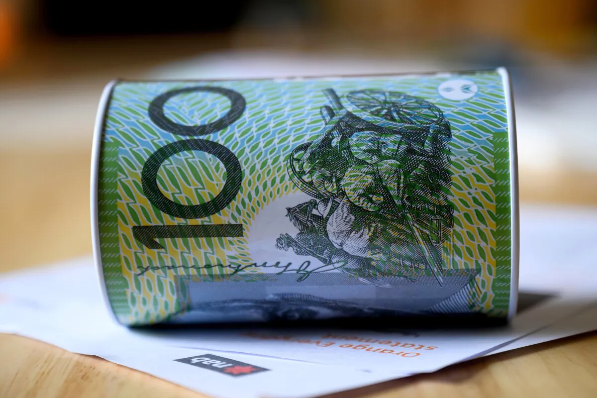 A stock photo of a money box with an Australian one hundred dollar note printed on it in Sydney, Australia on Dec. 21, 2024. (AAP Image/Bianca De Marchi) 