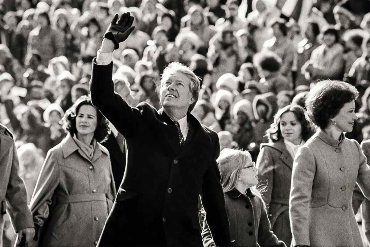 President Jimmy Carter waves to the crowd while walking with his wife, Rosalynn, and their daughter, Amy, along Pennsylvania Avenue from the U.S. Capitol to the White House following his inauguration, on Jan. 20, 1977. (Suzanne Vlamis, File/AP Photo)