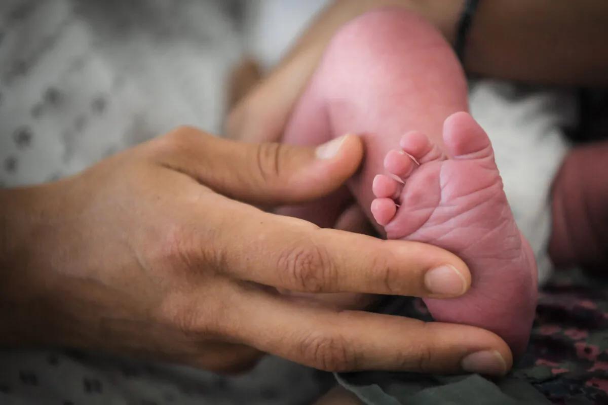 A woman touches her baby's foot in a file photograph. (Loic Venance/AFP via Getty Images)