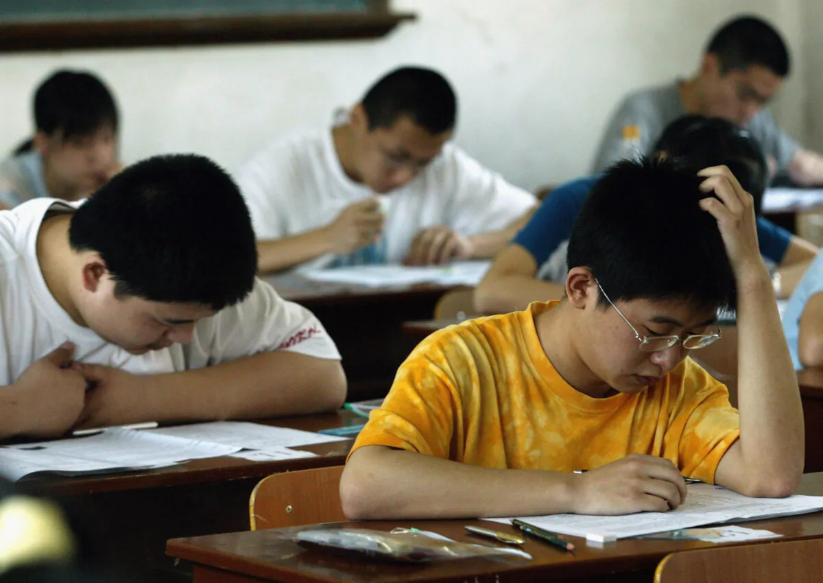 Students take part in the college entrance exam in an exam room in a middle school in Xian of Shaanxi Province, China, on June 7, 2005. (China Photos/Getty Images)