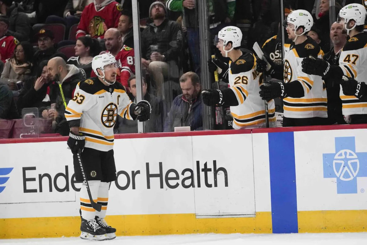 Boston Bruins left wing Brad Marchand, left, celebrates after scoring on the Chicago Blackhawks during the second period of an NHL hockey game Wednesday, Dec. 4, 2024, in Chicago. (Erin Hooley/AP Photo)