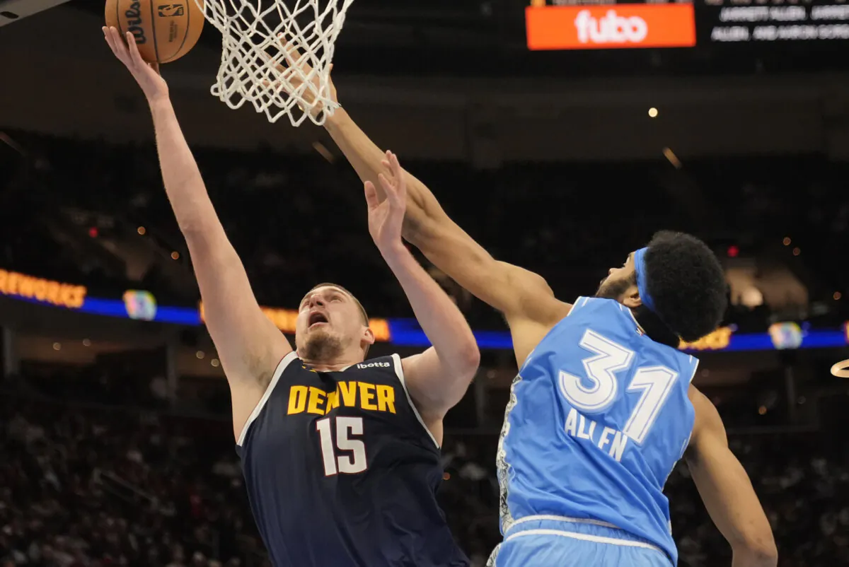 Denver Nuggets center Nikola Jokic (15) shoots in front of Cleveland Cavaliers center Jarrett Allen (31) in the second half of an NBA basketball game, Thursday, Dec. 5, 2024, in Cleveland. (Sue Ogrocki/AP Photo)