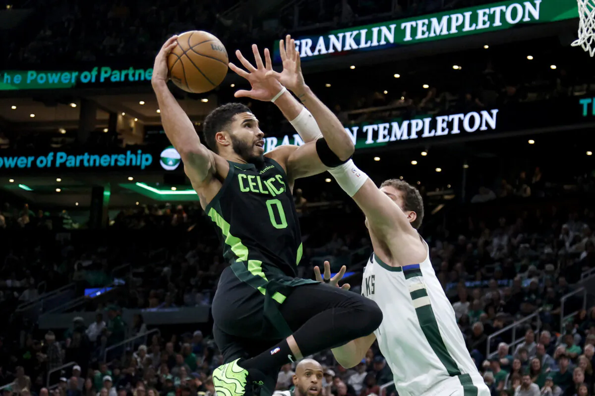 Boston Celtics forward Jayson Tatum (0) drives to the basket against Milwaukee Bucks center Brook Lopez (11) during the first half of an NBA basketball game in Boston, on Dec. 6, 2024. (Mary Schwalm/AP Photo)