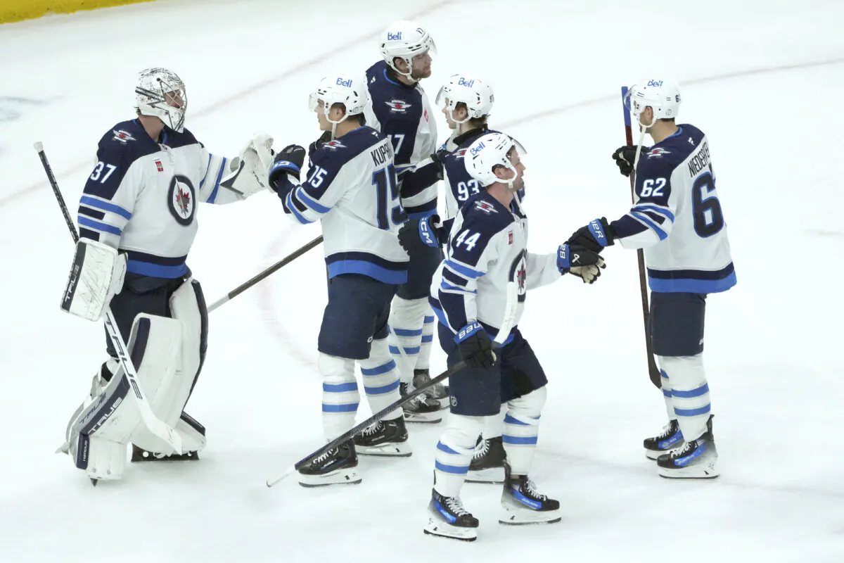 Winnipeg Jets goaltender Connor Hellebuyck (37) celebrate with teammates the team's 4-2 win over the Chicago Blackhawks in an NHL hockey game Saturday, Dec. 7, 2024, in Chicago. (Charles Rex Arbogast/AP Photo)