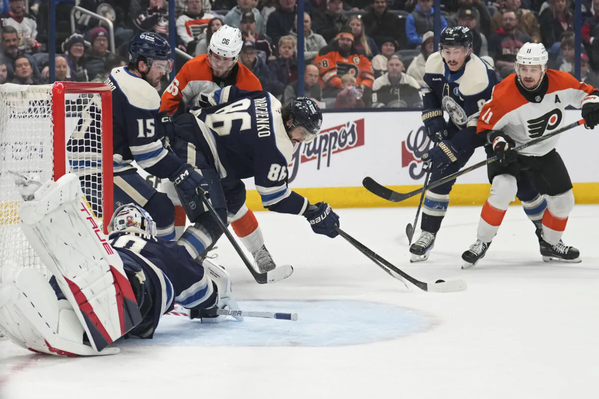 Columbus Blue Jackets right wing Kirill Marchenko (86) tries to clear the puck away from goaltender Elvis Merzlikins, left, in front of Philadelphia Flyers left wing Joel Farabee, third from left, and right wing Travis Konecny (11) in the first period of an NHL hockey game in Columbus, Ohio, on Dec. 10, 2024. (Sue Ogrocki/AP Photo)