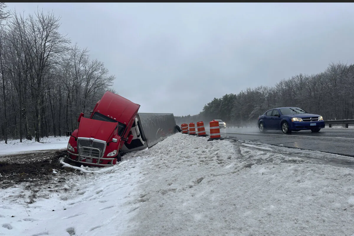 A tractor-trailer hauling a load of oranges sits on the side of the road after sliding off the Maine Turnpike in New Gloucester, Maine on Dec. 11, 2024. (David Sharp/AP Photo)