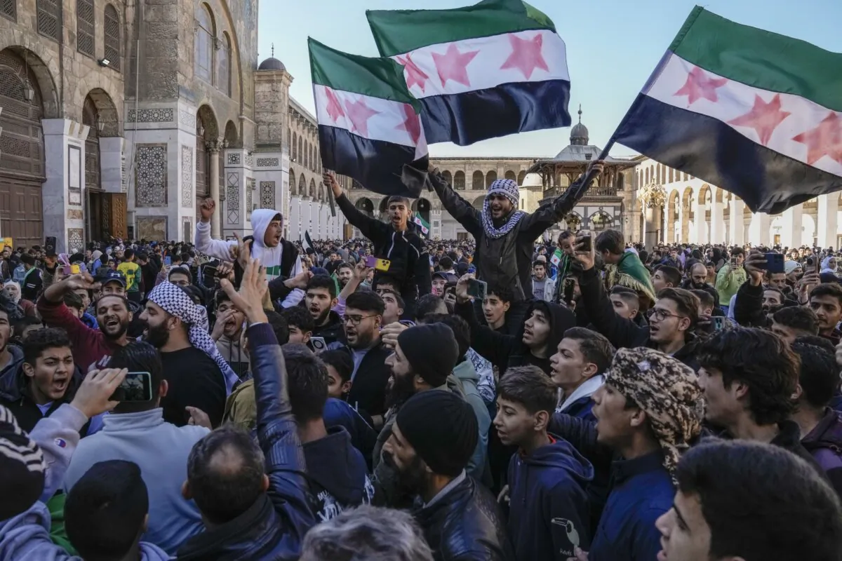 Syrians chant slogans and wave the new Syrian flag as they gather at the Umayyad Mosque in Damascus, Syria, on Dec. 13, 2024. (Leo Correa/AP Photo)