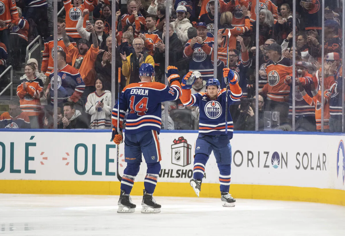 Edmonton Oilers' Mattias Ekholm (14) and Jeff Skinner (53) celebrate a goal against the Vegas Golden Knights during the third period of an NHL game in Edmonton, Alberta, Saturday, Dec. 14, 2024. (Jason Franson/The Canadian Press via AP)