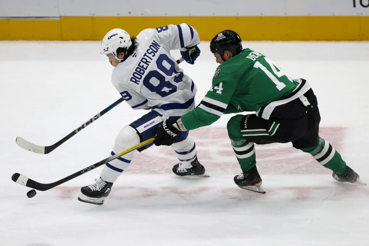 Dallas Stars left wing Jamie Benn (14) tries to get the puck from Toronto Maple Leafs left wing Nicholas Robertson (89) during the second period of an NHL hockey game in Dallas, Wednesday, Dec. 18, 2024. (Michael Ainsworth/AP Photo)