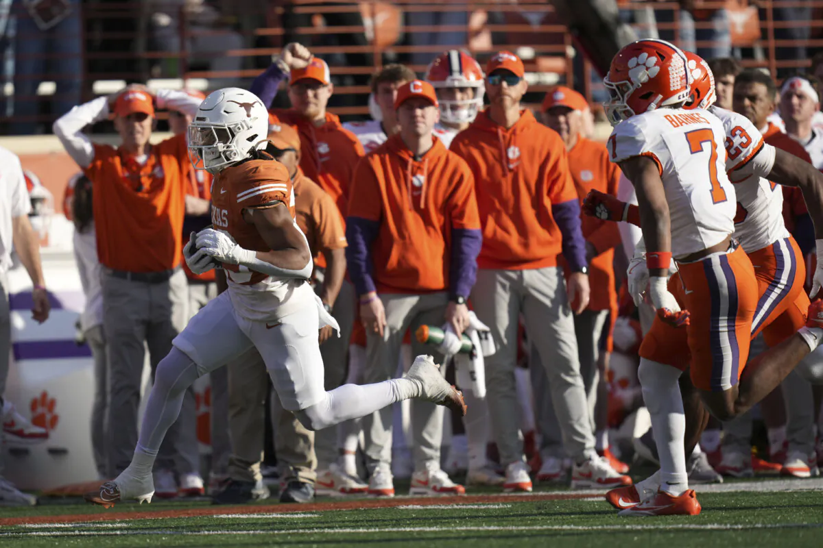 Texas running back Jaydon Blue, left, runs from Clemson safety Khalil Barnes (7) during a 38-yard touchdown run in the first half in the first round of the College Football Playoff, Saturday, Dec. 21, 2024, in Austin, Texas. (Eric Gay/AP Photo)