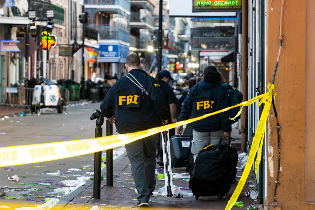 FBI investigators arrive at the scene where the white Ford F-150 pickup truck crashed into a work lift after allegedly driving into a crowd of New Year's revelers in the French Quarter of New Orleans on Jan. 1, 2025. (Matthew Hinton / AFP via Getty Images)