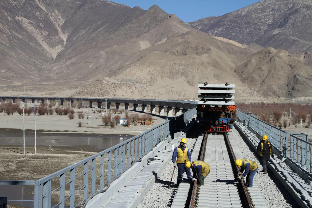 Workers are seen on railway tracks at a bridge over the Yarlung Zangbo River as they work on the construction of the railroad linking Lhasa and Nyingchi, in Tibet, China, on Nov. 26, 2018. (Zhao Lang/CNS via Reuters)