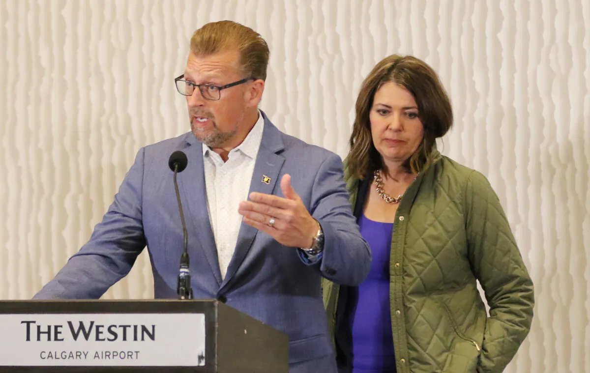 Alberta Deputy Premier and Minister of Public Safety Mike Ellis answers media questions as Alberta Premier Danielle Smith looks on in Calgary on Aug. 25, 2023. (The Canadian Press/Dave Chidley)
