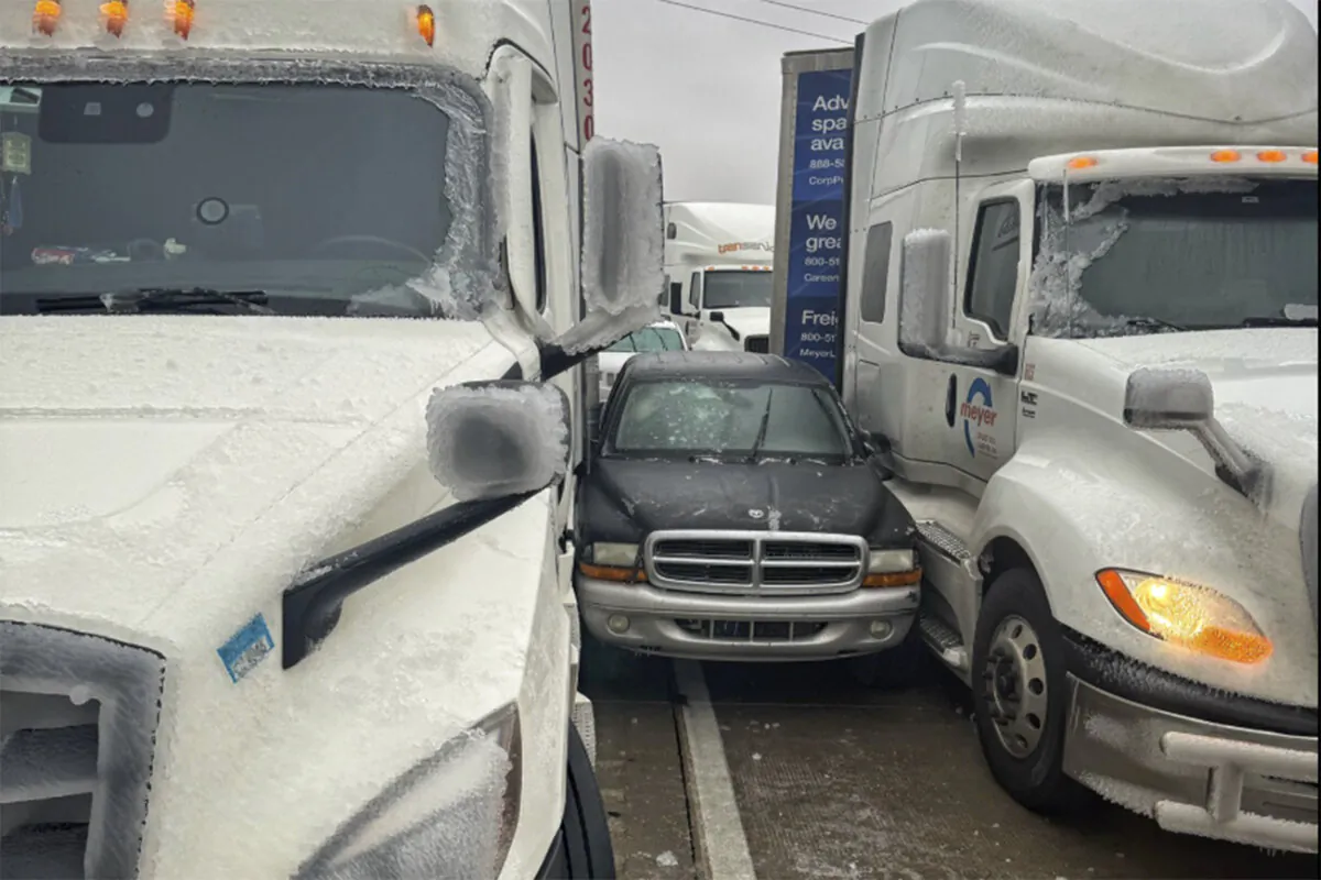 A car is wedged between two trucks during icy weather in Salina, Kan., on Jan. 4, 2024. (Kansas Highway Patrol via AP)