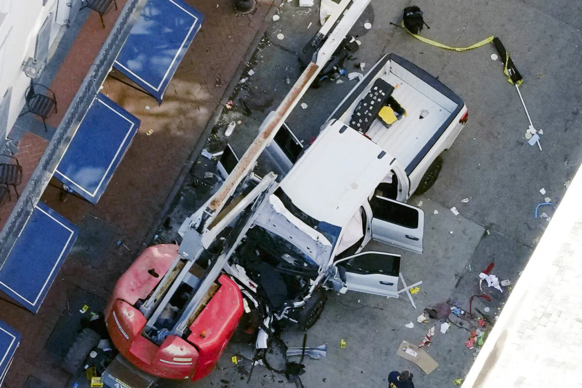A black flag with white lettering lies on the ground rolled up behind a pickup truck that a man drove into a crowd on Bourbon Street in New Orleans, killing and injuring a number of people, on the early morning of Jan. 1, 2025. (Gerald Herbert, File/AP Photo)