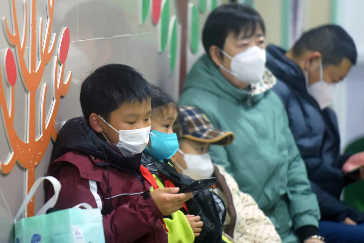 Masked children and adults wait to be seen at the pediatric department of a hospital in Hangzhou, China, on Jan. 6, 2025. (AFP via Getty Images)