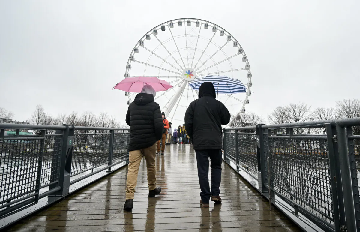 People walk toward the Ferris wheel in Montreal's Old Port on New Year's Day, Jan. 1, 2025. (The Canadian Press/Graham Hughes)