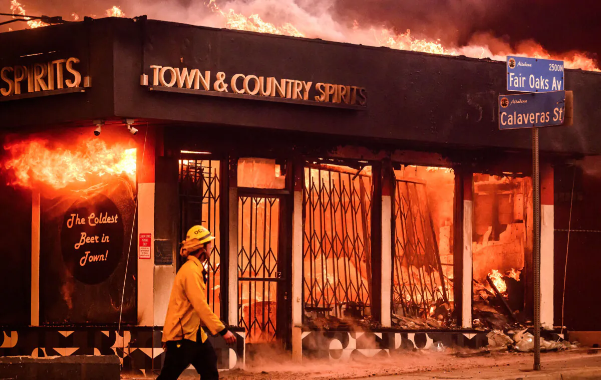 A firefighter walks passed a burning liquor store during the Eaton fire in the Altadena area of Los Angeles County, California on Jan. 8, 2025. (Josh Edelson/AFP via Getty Images)