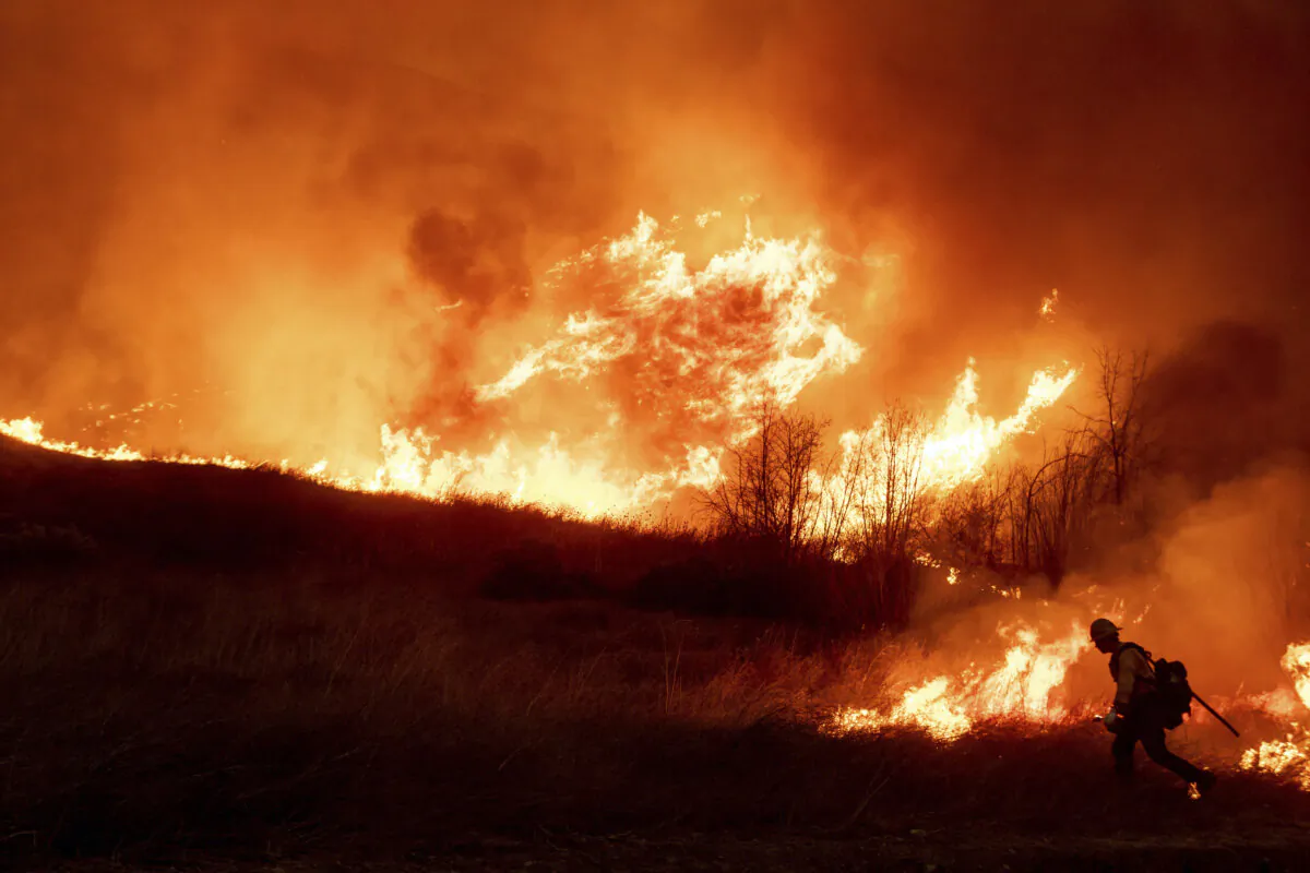A firefighter sets a backburn in front of the advancing Kenneth Fire in the West Hills section of Los Angeles on Jan. 9, 2025. (Ethan Swope/AP Photo)