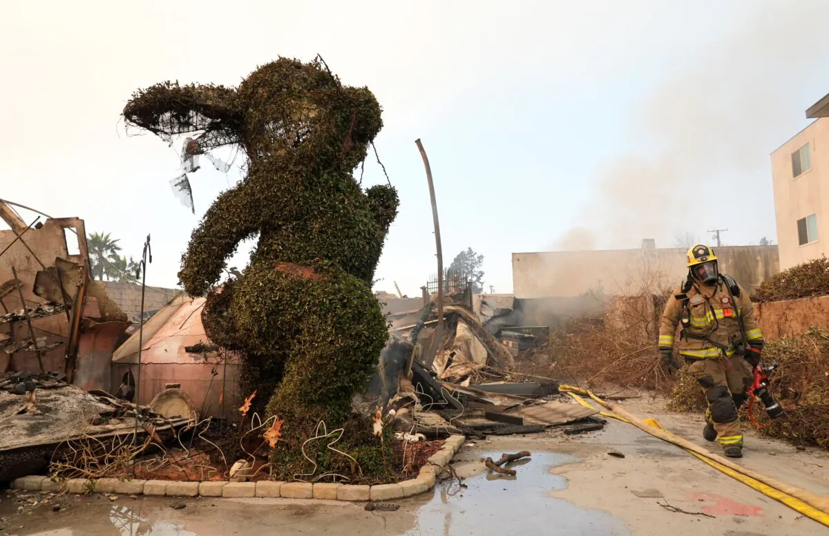 A firefighter walks past a charred bunny sculpture and debris at the destroyed Bunny Museum in Altadena, Calif., on Jan. 9, 2025. (Chris Pizzello/AP Photo)