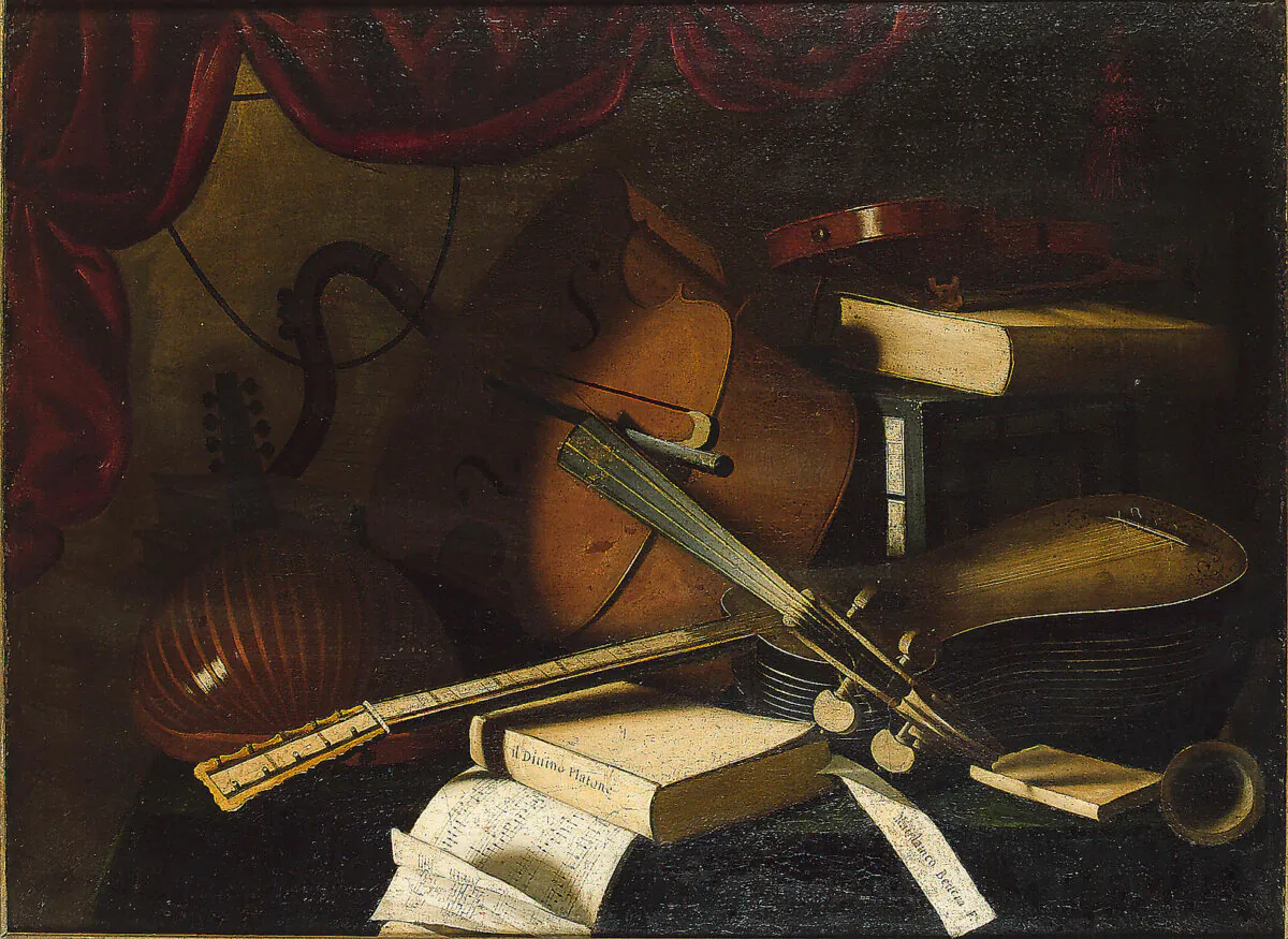 A painting of a lute, cello, violin, guitar, musical manuscript and books on a draped table by an unknown artist. Oil on canvas; 27 11/12 inches by 38 1/12 inches. (Public Domain)