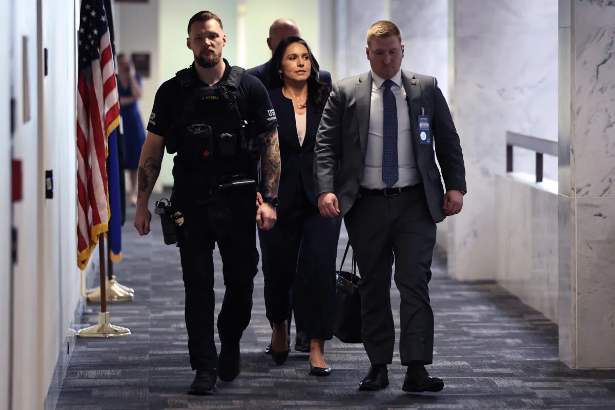 Former U.S. Rep. Tulsi Gabbard from Hawaii is escorted by police as she moves between meetings with senators in the Hart Senate Office Building on Capitol Hill in Washington on Dec. 18, 2024. (Chip Somodevilla/Getty Images)