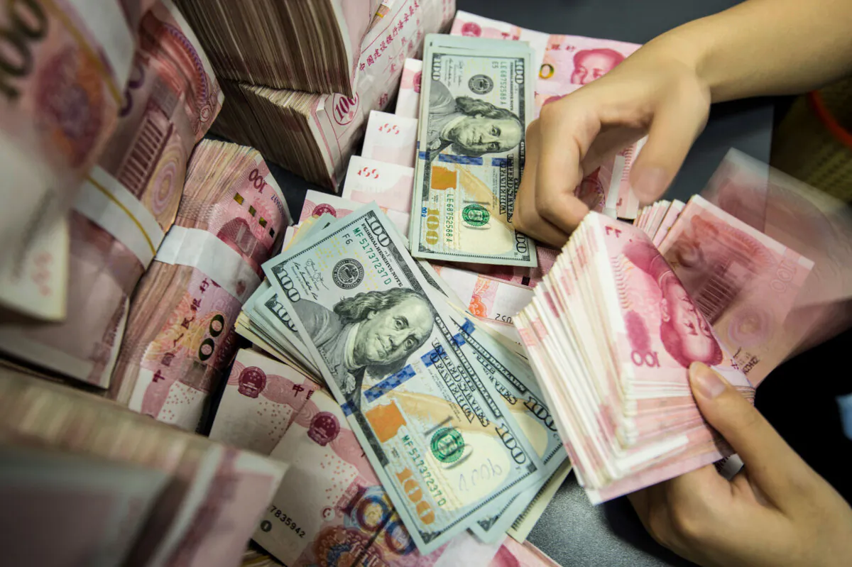A Chinese bank employee counts 100-yuan notes and U.S. dollar bills at a bank counter in Nantong in Jiangsu Province, China, on Aug. 28, 2019. (AFP via Getty Images)