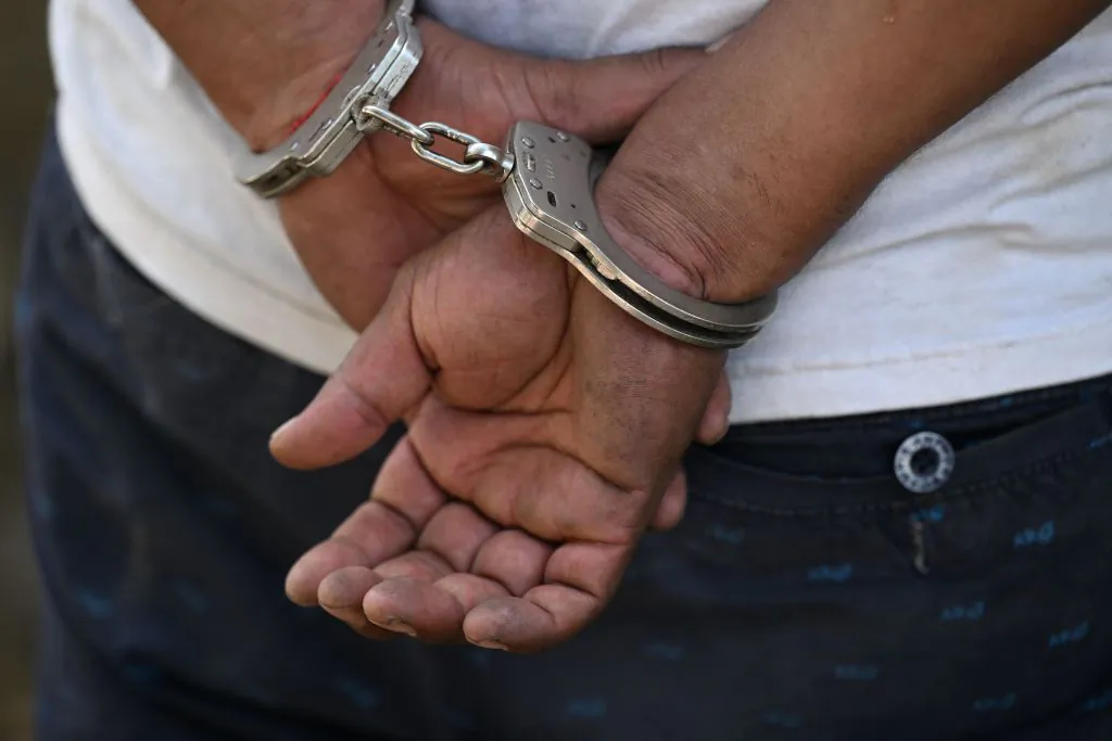 A man remains handcuffed. (Marvin Recinos/AFP via Getty Images)
